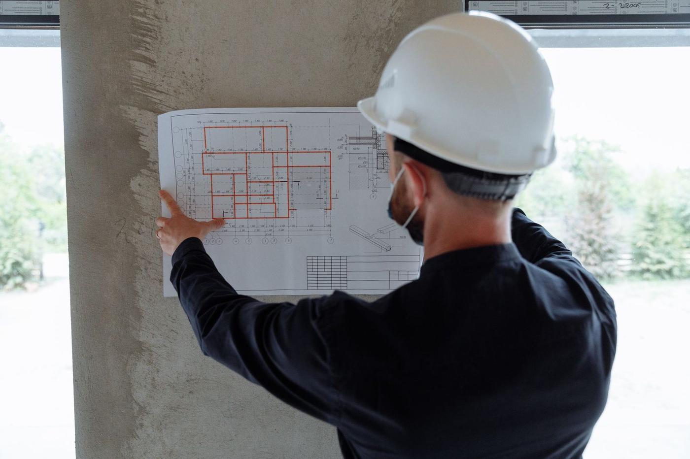 مهندس و تکنسین فنی در حال بررسی نقشههای ساختمانی